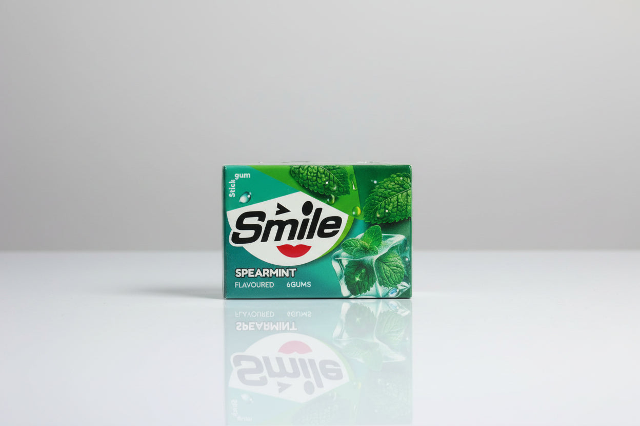 Three packs of Smile Spearmint chewing gum tied together with red string on a light gray background.