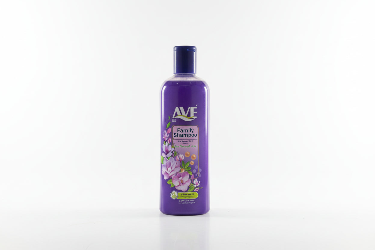 Purple Ave Family Shampoo bottle on a grass-like surface with shelves in the background