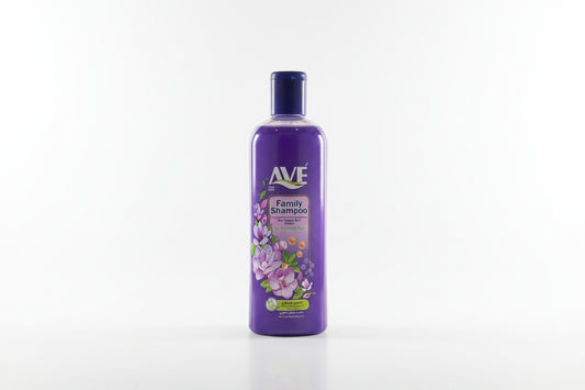 Purple Ave Family Shampoo bottle on a grass-like surface with shelves in the background